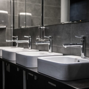 Interior of a modern public bathroom toilet in grey colors.